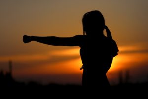 girl doing karate during sunset